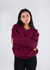 A maroon V-neck fleece jumper on a model, featuring a relaxed fit and long sleeves.