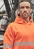 An orange unisex water-resistant hoodie with segmented tape, featuring a hood and a branded logo on the sleeve.