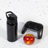 A drink bottle with a free flow lid, presented in sleek black, alongside a gaming controller and a red apple.