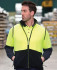 A high-visibility polar vest in bright yellow and black, featuring a zip and collar, worn by a man.