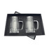 A set of two clear glass beer mugs, presented in a black gift box with a velvet interior.