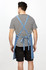A striped men's T-shirt worn under a denim apron, showcasing the back and straps. The outfit includes black shorts.