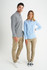 A man and woman model stylish button-up shirts in check and striped patterns, paired with beige pants and casual shoes.
