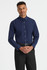 A men's long sleeve button-up shirt in navy blue, featuring a collar and buttons down the front, worn with black trousers.