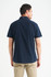 A navy short sleeve button-up shirt with a collar, featuring a back view of a model.