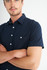 A navy blue short sleeve button-up shirt featuring a chest pocket and white buttons.