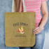 A jute tote bag in natural brown with a design featuring a bird and text. It has a logo and canvas handles.