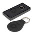 A round black leather key ring with a metal keychain, presented in a sleek black box.