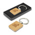 A square wooden key ring with a silver metal ring, presented in a black box.