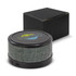 A wireless speaker with a grey fabric finish, featuring a round shape and a black base, alongside a black box.