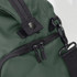 A green duffle bag featuring a sturdy zipper, clasp, and adjustable strap. It includes one logoed detail.