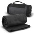 A rolled black fleece blanket with a strap lies beside an unrolled version, showcasing its soft texture.
