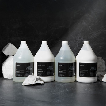 Amenie Sicilian Tangerine gallon-size product sampler on gray stone background with soft lighting