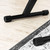 Bottom feet of Tiger X-frame keyboard stand, black rubber-capped stabiliser bars on a wooden floor.