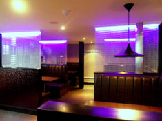 Chain used as partitions in a dining area. Attached to the lighting strips, this allows the light to flow down onto the booths.