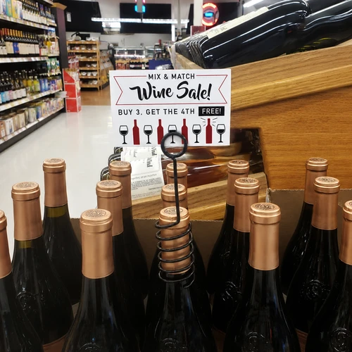 Bottle top promotional sign holder clip. Fits over the neck of bottles for secure display of tags and signs.