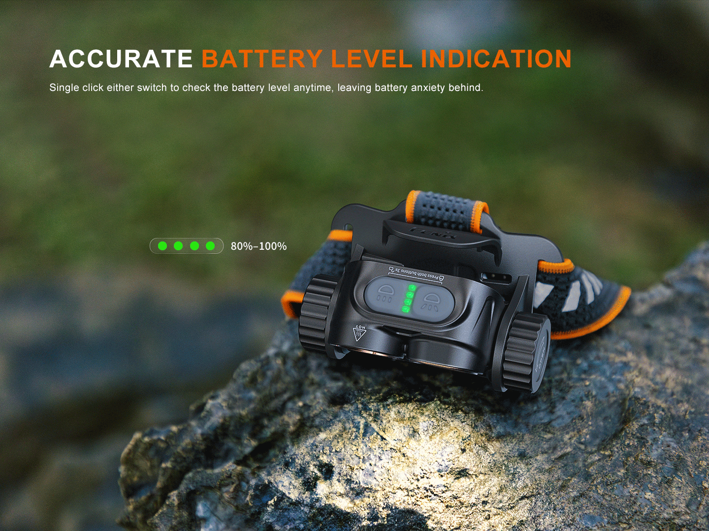 Fenix HM65R V2.0 headlamp on a rock, displaying green LED lights for accurate battery level indication.