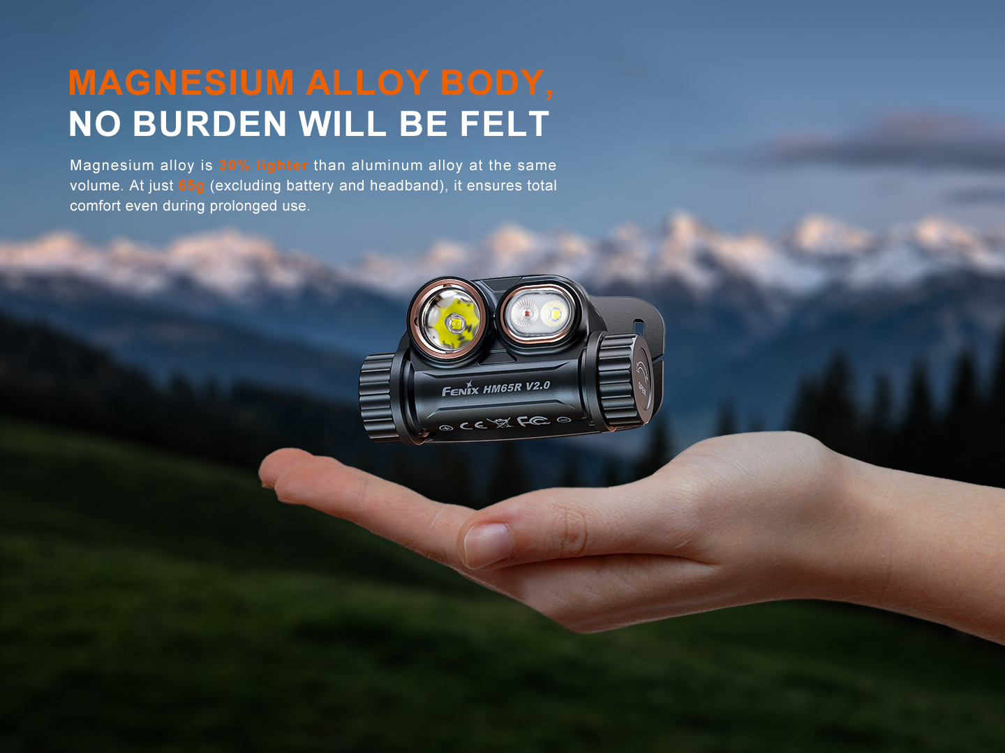 Fenix HM65R V2.0 headlamp resting on an open palm, showcasing its lightweight magnesium alloy body with mountains background.