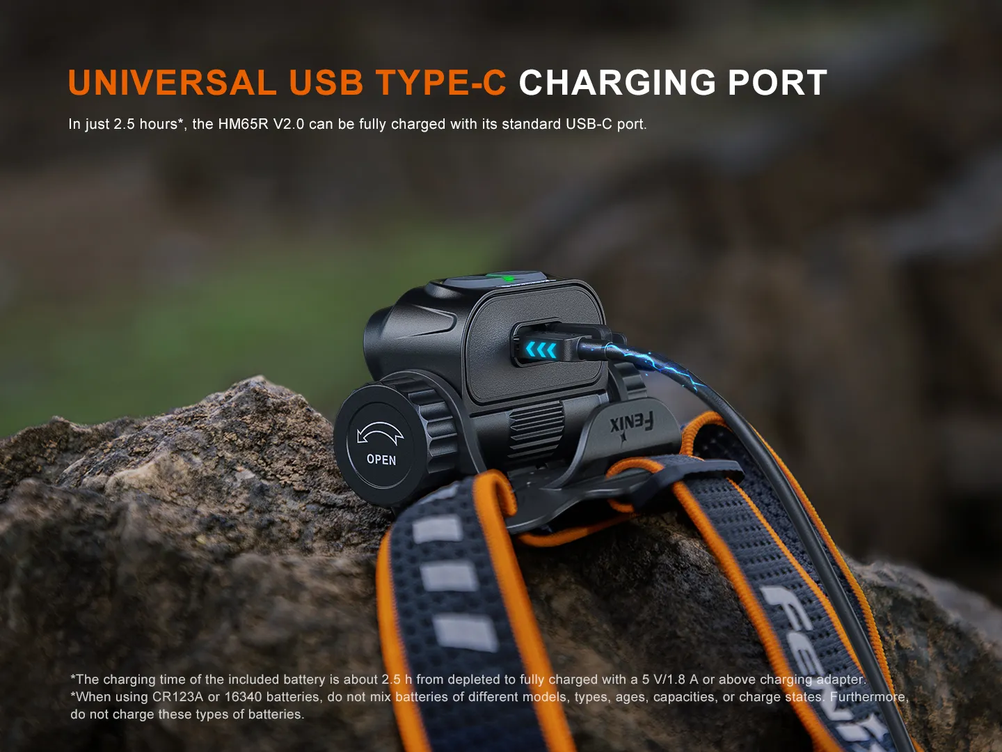 Fenix HM65R V2.0 headlamp on a rock, showing the universal USB Type-C charging port in use.