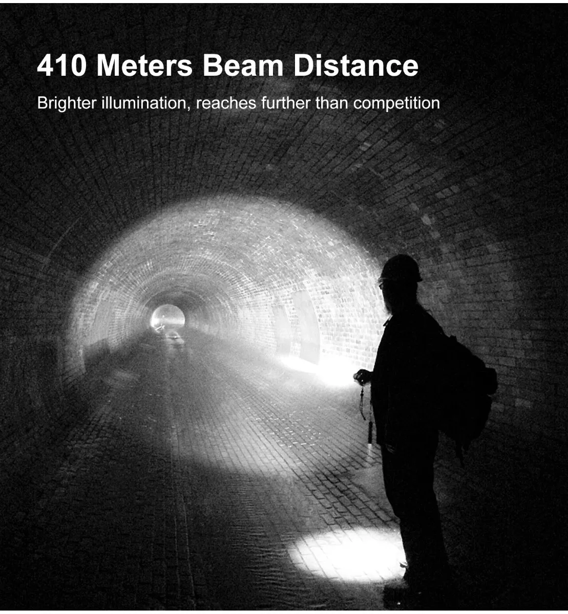 Person with a hard hat using a flashlight to illuminate a long, dark tunnel, showcasing 410 meters beam distance.