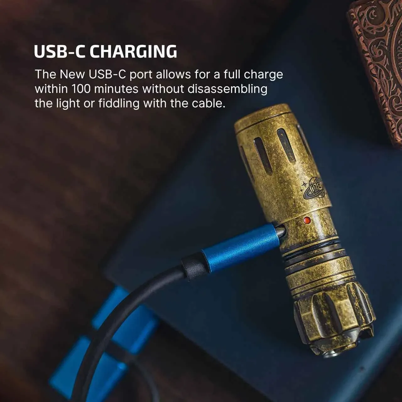 The Olight i18 Brass Limited Edition Keychain Light is shown charging via its convenient USB-C port.