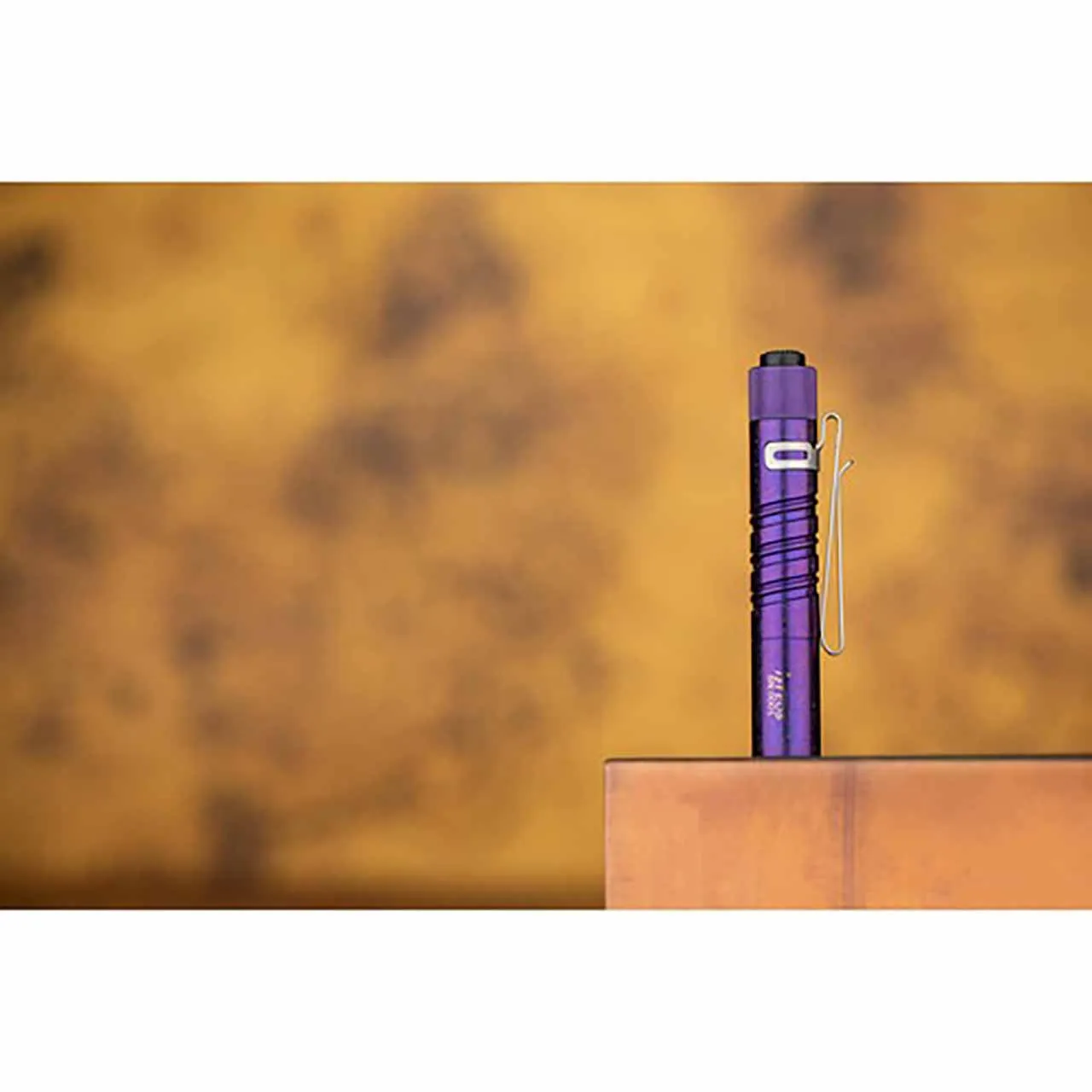 Olight i3T Titanium Periwinkle Purple Limited Edition 180 Lumen LED Torch standing upright on a wooden surface.