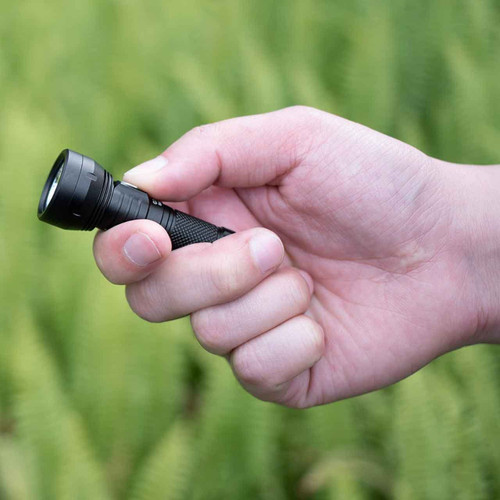 Hand holding the black Lumintop GT Nano 3.0 700 Lumen USB-C Rechargeable Mini Torch outdoors, ready for use.
