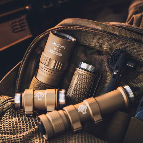 Disassembled tan Weltool W15 flashlight components and accessories laid out on a tactical bag.