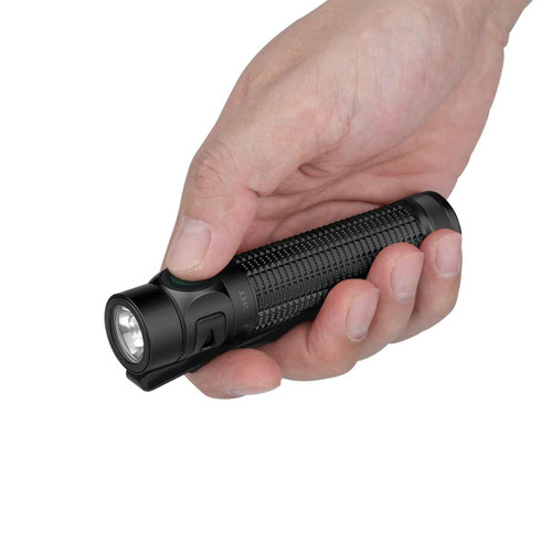 Hand holding the black Olight Baton 4 Pro flashlight, demonstrating its compact size.