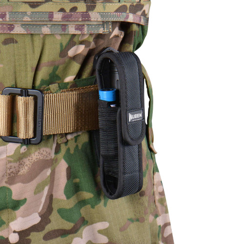 Wuben AS5 flashlight nylon pouch holder on a tactical belt, holding a flashlight, against camouflage pants.