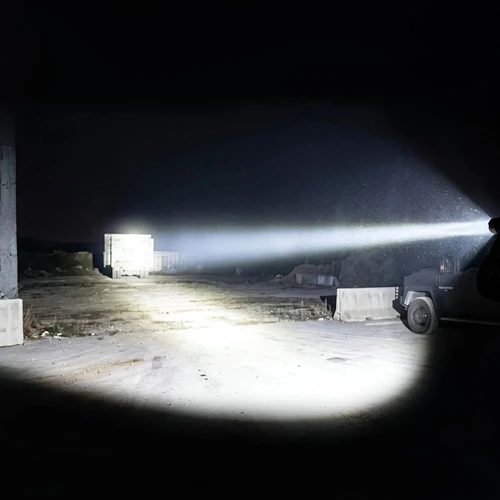 Acebeam Defender P17 - 4900 Lumen Dual-switch Tactical Torch illuminating a dark industrial area at night.