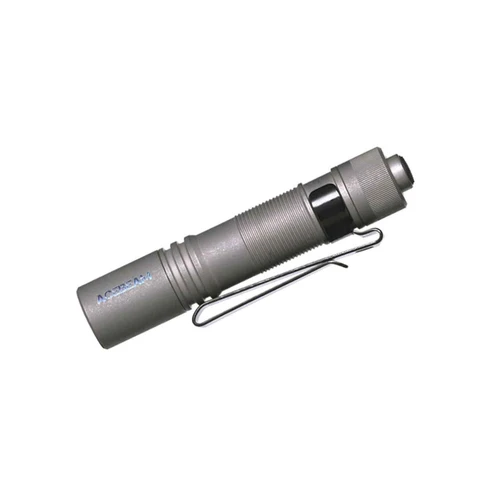 Angled view of a Pokelit AA Titanium flashlight with a black pocket clip, showing the side and tail cap.