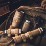 Disassembled tan Weltool W15 flashlight components and accessories laid out on a tactical bag.