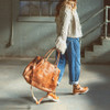 A model carrying a BedStu leather large Rockaway Tan Rustic bag. 