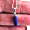 Blue Lapis crystal point pendant, sterling silver necklace in my hand.  Blue Lapis crystal point pendant, sterling silver necklace in my hand.