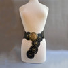 Black faux leather and gold coin buckle and grommet detail. 