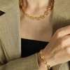 Chunky gold-plated stainless steel adjustable bracelet with matching necklace on a model. 