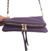 Dark plum shoulder purse with a chain shoulder strap, close-up picture of zipper. 