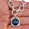 Sapphire-blue Swarovski crystal silver-plated necklace in my hand, close-up.