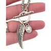 Silver-plated wing and clear crystal charm toggle necklace in my hand. 