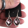 Pink crystal dangle earrings in my hand. 