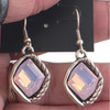 Pink crystal dangle earrings in my hand. 