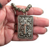 Cross gunmetal necklace in my hand. 