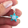 Sterling silver five-point star pendant with Kingman turquoise and opal inlay handcrafted in New Mexico, USA in my hand.