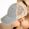 Woman wearing a faded gray distressed baseball cap with breathable tan mesh back, curved bill, and high ponytail opening.