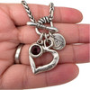 Close-up of a silver-plated toggle bracelet showing the textured open heart, faceted deep red stone, and Pacific Northwest charm for size and detail.