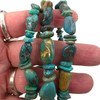 Three turquoise nugget elastic stretch bracelets displayed in hand, highlighting assorted polished stones, unique shapes, and beautiful blue and green colors.