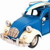 Close-up of a vintage blue VW Beetle metal decorative car highlighting the distressed cream fenders, silver-tone headlights, front grille, bumper, detailed wheels, and surfboard mounted on the roof.