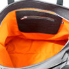 Inside orange fabric of black leather travel bag with silver skull. 