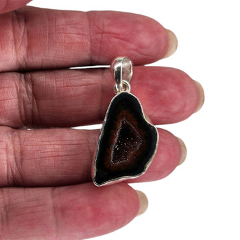 Burgundy Coconut Geode Druzy sterling silver pendant in my hand. 